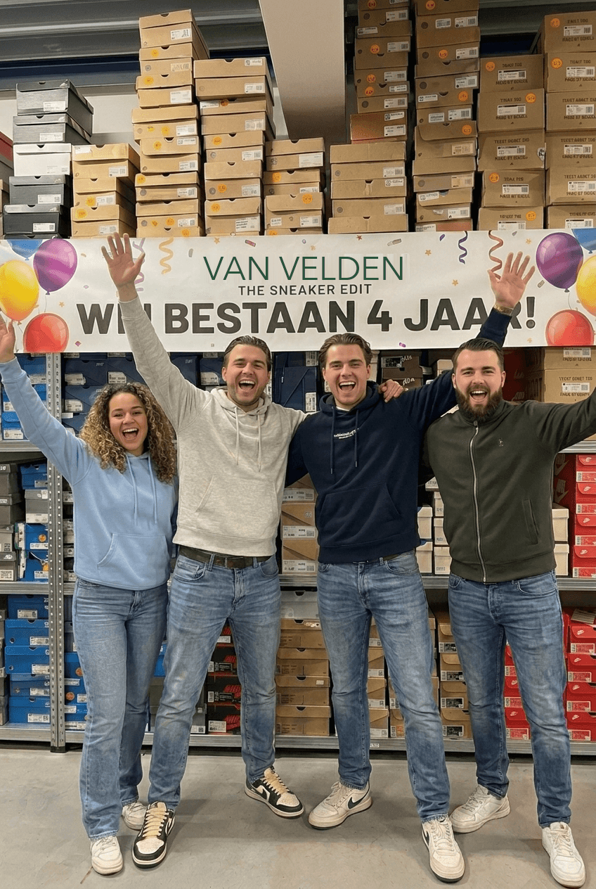 Het Van Velden-team viert vier jaar onder de jubileumbanner in het sneakermagazijn